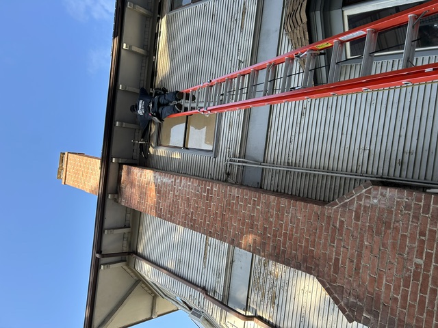 Cozy Conditions technician working at roofline