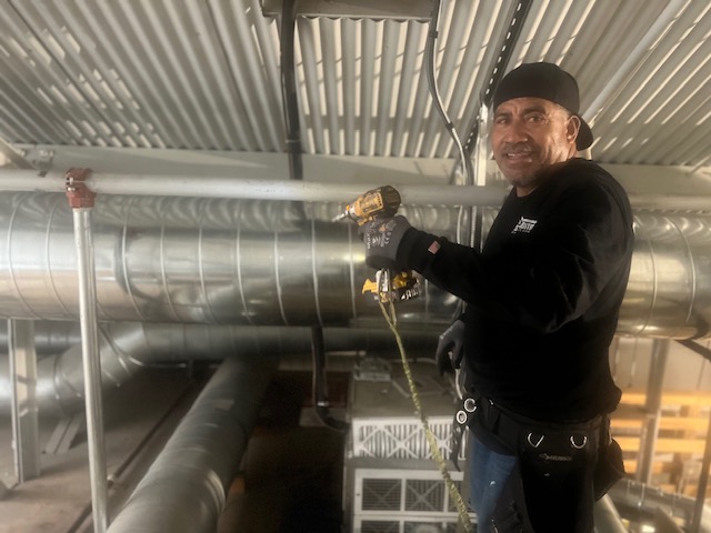 Cozy Conditions technician at work on a light commercial HVAC install